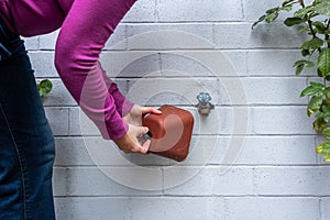 Winterization, womanÃ¢â¬â¢s hands installing foam and plastic faucet cover to prevent pipes freezing photo